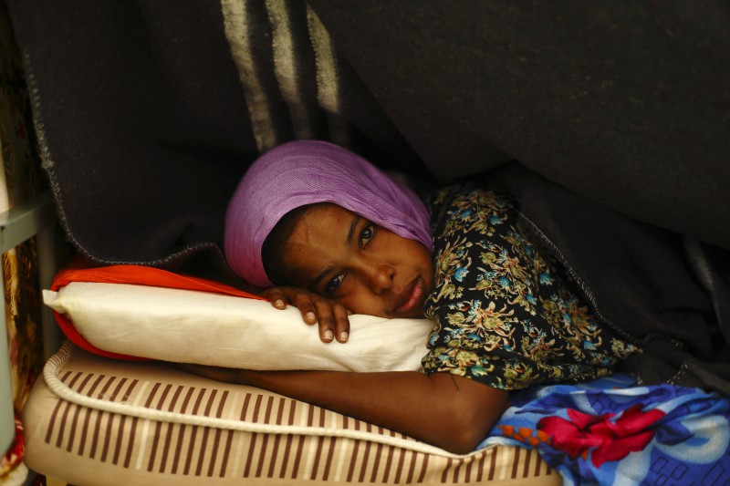 A Somali woman lies on her bed in a dormitory at the Lyster barracks detention centre for immigrants, which currently holds 236 detainees, in Hal Far, outside Valletta, October 22, 2013. 